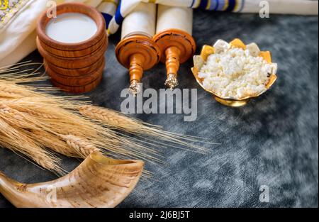 Jüdischer Feiertag Shavuot für koscheres Milchessen auf torah Scroll und tallis Stockfoto