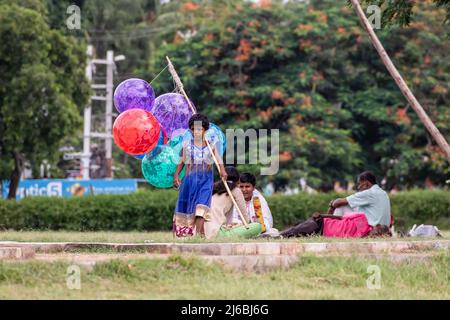 Vellore, Tamil Nadu, Indien - 2018. September: Eine indische Straßenverkäuferin, die in einem Park läuft und bunte Ballons auf einem Stock verkauft. Stockfoto