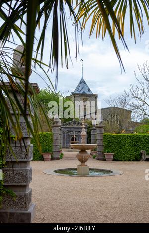 Eleganter Brunnen und Holztempel im Colllector Earl's Garden: Turm der St. Nichola Church Beyond, Arundel Castle Gardens, West Sussex, Großbritannien Stockfoto