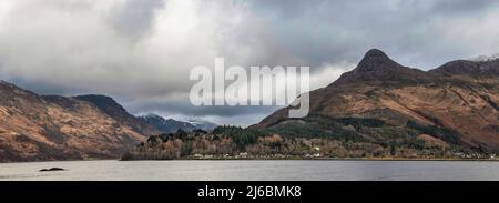 Wunderschöner Blick auf die Winterlandschaft entlang des Loch Leven in Richtung schneebedeckter Berge in der Ferne mit dramatischem Himmel Stockfoto