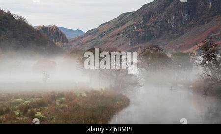 Atemberaubende Herbstlandschaft Sonnenaufgang Bild in Richtung Borrowdale Valley von Derwentwater im Lake District mit Nebel Rollen über die Landschaft Stockfoto