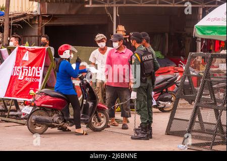 Phnom Penh, Kambodscha. 8. Mai 2021. Nachdem die Stadt 3 Wochen lang vollständig gesperrt war, hat die Regierung Phnom Penh aufgrund des anhaltenden COVID-Anstiegs in 3 Farbzonen (rot, orange und gelb) unterteilt. Eine kambodschanische Frau zeigt ihren Papierkram an einem Polizeikontrollpunkt am Eingang einer „Roten Zone“, was ein hohes Infektionsrisiko bedeutet. Quelle: Kraig lieb / Alamy Live News Stockfoto