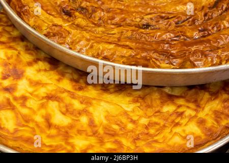 Backblech. Butter- und Spinatteig auf weißem Hintergrund. Nahaufnahme. Lokaler Name su boregi ve ispanakli borek Stockfoto