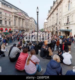 London, Greater London, England, April 23 2022: Menschenmassen versammeln sich im Piccadilly Circus, um sich die Straßenunterhaltung anzusehen. Stockfoto