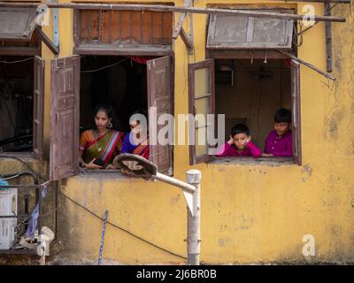 Mumbai, Indien - 02. April 2022 : Kinder in traditioneller Kleidung beobachten die Hindu-Parade vom Hausfenster aus. Stockfoto