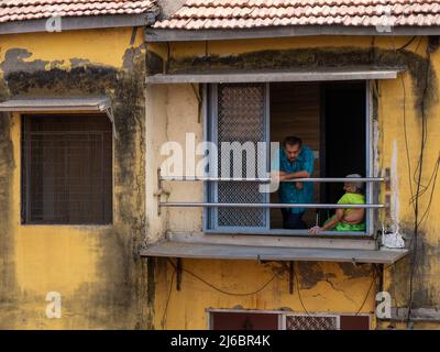 Mumbai, Indien - 02. April 2022 : Familie beobachtet die Hindu-Parade zum neuen Jahr vom Hausfenster aus. Stockfoto