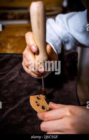 Die junge chinesische Geigenbauerin signiert den Jumper ihrer Geige mit Feuer und trägt ihren Namen in der Werkstatt Stockfoto