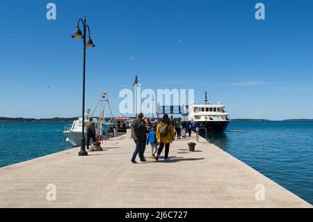 Fazana, Kroatien - 11. April 2022: Menschen warten auf der Anlegestelle für die Fähre zum Nationalpark Brijuni Inseln Stockfoto