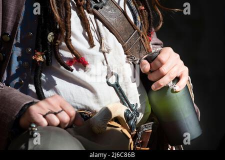 Piratenkostüm, das die Flasche Rum hält Stockfoto