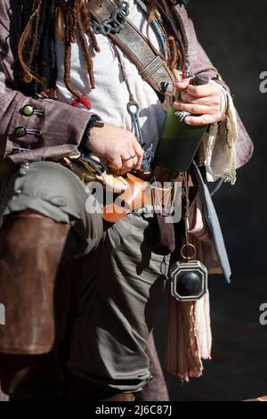 Piratenkostüm, das die Flasche Rum hält Stockfoto