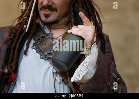 Piratenkostüm, das die Flasche Rum hält Stockfoto