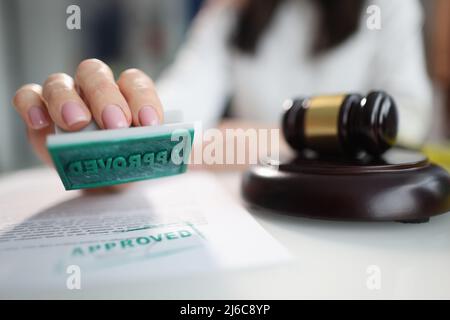 Weibliche Hand mit genehmigter Marke, Richter gavel Stockfoto