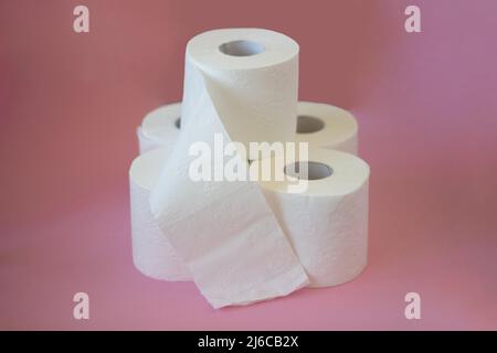 Rollen aus weißem Toilettenpapier auf einem rosa Hintergrund Stockfoto