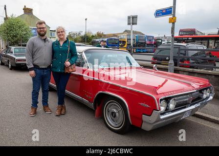 Camborne,Cornwall,UK,30.. April 2022,Ein Paar stand am TreviThick Day an einem alten texanischen Auto, das vor der Camborne Bushaltestelle geparkt war. Richard Trevidick (13. April 1771 – 22. April 1833) war ein britischer Erfinder und Bergbauingenieur, der heute in der jährlichen Parade gefeiert wurde, die leider seit drei Jahren abgesagt wurde. .Credit: Keith Larby/Alamy Live News Stockfoto