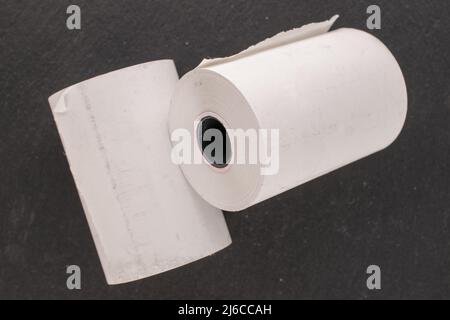 Mehrere Rollen Papierband für eine Kasse auf einem Schieferstein, Makro, Draufsicht. Stockfoto