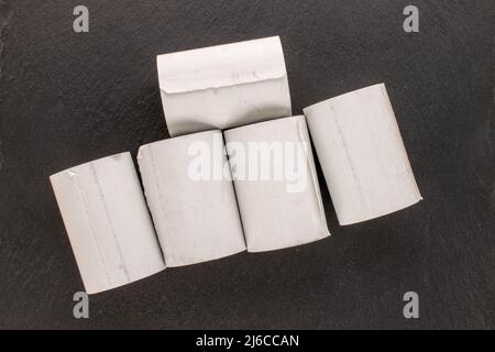 Mehrere Rollen Papierband für eine Kasse auf einem Schieferstein, Makro, Draufsicht. Stockfoto