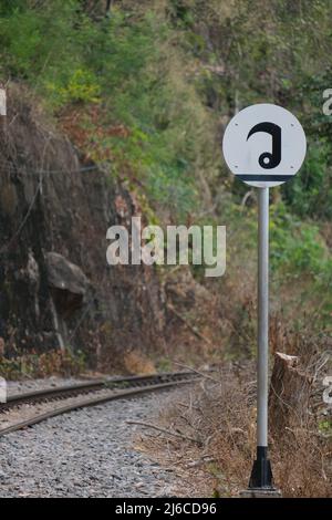 Ein seltsames einheimisches Straßenschild auf einer alten Schmalspurbahn in Thailand Stockfoto