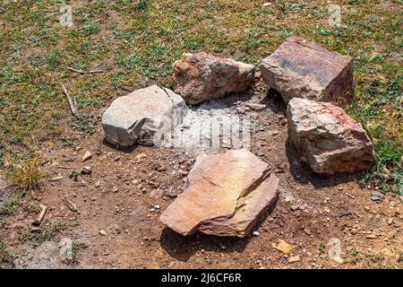 Blick von oben auf das erloschene Lagerfeuer in der bergigen Gegend. Stockfoto