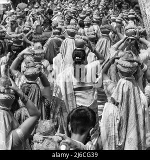 Frauen mit Kalash am Kopf während des Jagannath-Tempels Mangal Kalash Yatra tragen indische Hindu-Anhänger irdische Töpfe mit heiligem Wasser und Kokosnuss o Stockfoto