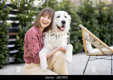 Porträt einer Frau mit ihrem Hund im Hinterhof Stockfoto