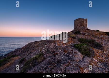 Morgenstimmung - Ruinen des alten Küstenwachturms Torre Argentina auf einem Felsen über der Westküste Sardiniens im Mittelmeer bei Sonnenaufgang Stockfoto