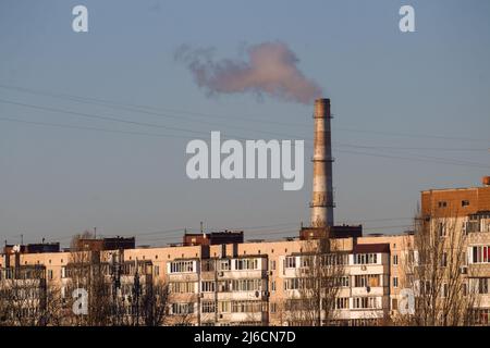 Rohre einer alten Fabrik werfen Wolken aus giftigem weißem Rauch in den Himmel, die die Atmosphäre verschmutzen. Städtischer Smog durch Rauch aus Kesselhäusern. Weiße s Stockfoto