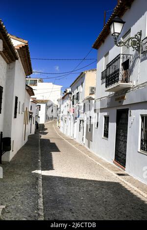 Altea, Alicante, Spanien- 24. April 2022:schmale Gassen und wunderschöne weißgetünchte Fassaden an einem sonnigen Wintertag in Altea, Alicante, Spanien Stockfoto