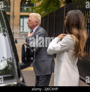 Bild zeigt: Boris Becker straightens seine Wimbledon Krawatte im Fenster Spiegelung eines Taxis, als er in seiner Wimbledon Krawatte in der Spiegelung von Th ankommt Stockfoto