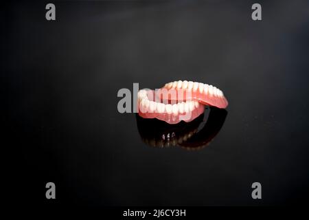 Anatomiemodell für menschliche Zähne und Kiefer zur medizinischen Illustration isoliert auf schwarzem Hintergrund mit Platz für Text. Gesunder Zahn, Zahnpflege und Orthopädie Stockfoto