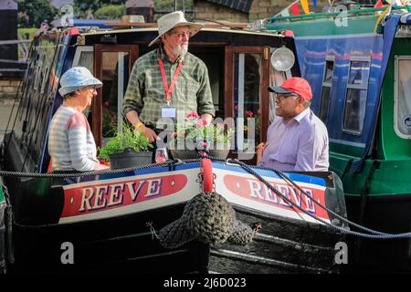 London, Großbritannien, 30.. April 2022. Bootsbesitzer unterhalten sich am späten Nachmittag auf ihren Terrassen. Dutzende von wunderschön dekorierten Schmalbooten, Lastkähne und Kanalbooten nehmen am IWA Canalway Cavalcade Festival Teil, das am Wochenende der Bankfeiertage Anfang Mai in das Londoner Little Venice zurückkehrt. Organisiert von der Inland Waterways Association (IWA), feiert es das Leben der Boote mit einem Bootsanlegeplatz sowie Musik, Ständen und Familienunterhaltung entlang des Grand Union Canal. Stockfoto