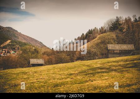 Holzscheune auf Tierfarm.hügelige Landschaft im Hintergrund. Stockfoto