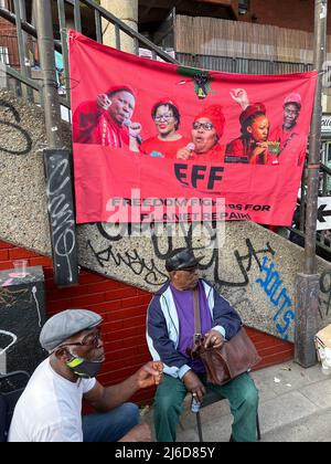 Während einer internationalistischen Friedensmesse in Brixton wird ein Banner der wirtschaftlichen Freiheitskämpfer gesehen, während die Menschen den Rednern zuhören. Die Economic Freedom Fighters (EFF) ist eine südafrikanische radikale und militante wirtschaftliche Emanzipationsbewegung unter der Führung von Julius Malema. Stockfoto