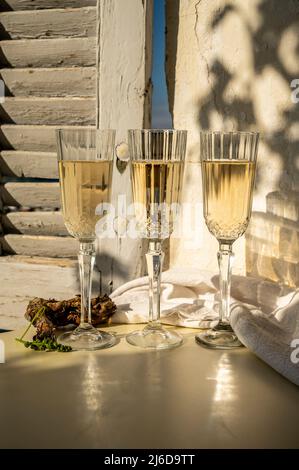 Drei Gläser französischer Champagner Sekt und Blick auf bunte Fischerboote im alten Hafen von Cassis, Provence, Frankreich, Sommerfest in PR Stockfoto