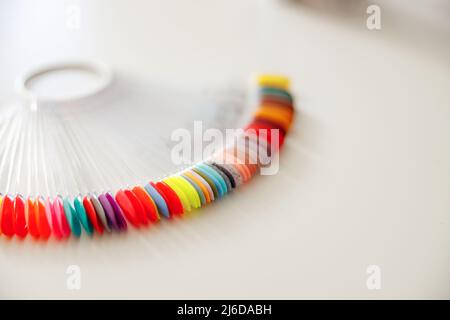 Bunte Kunststoff-Nagel-Tipps auf dem Tisch im Schönheitsshop Stockfoto