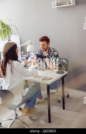 Selbstbewusste Frau mit Nagelmaniküre in Nail Art Studio Stockfoto