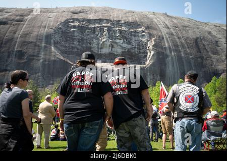 30. April 2022, Stone Mountain, Georgia, USA: Sons of the Confederacy Gastgeber einer Einhaltung der Confederate Memorial Day an der Basis von Stone Mountain, unter der Schnitzerei der konföderierten Helden Gen. Robert E. Lee, â € œStonewallâ € Jackson und Konföderation Präsident Jefferson Davis. Die Veranstaltung wurde von Demonstranten aus Black Lives Matter-Gruppen in der Region, die auf die Entfernung des Schnitzwerks drängen, von dem sie sagen, dass es Hass und Rassismus ehrt, abgestürzt ist, zusammengekracht.im Bild: Mitglieder von Sons of the Confederacy beobachten, wie der Gedenkgottesdienst weitergeht und ignorieren die Demonstranten, die mehrere hundert Meter entfernt sind. (Bild: © Robin Rayne/ZUMA Stockfoto