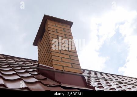 Schornstein auf Dachmaterialien Rotmetall Dachziegel Bleche Stockfoto