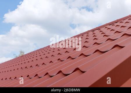 Modernes Dach mit effektbeschichteten roten Metalldachziegeln Stockfoto