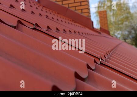 Dekorative Metalldach Hintergrundstruktur auf roten Metalldachziegeln Stockfoto