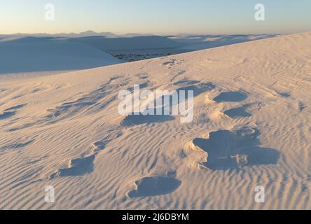 Bei Sonnenuntergang brechen im White Sands National Park Formationen aus gehärtetem Sand durch die Gipssanddünen Stockfoto