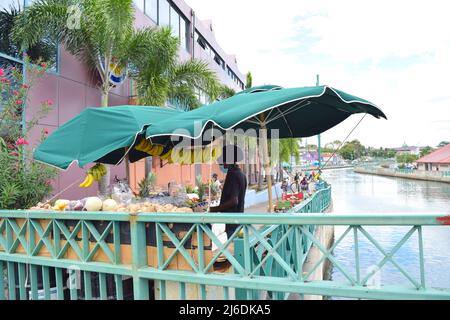 Ein einheimischer Mann mit Gesichtsmaske verkauft in Bridgetown Barbados Obst. Stockfoto