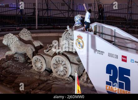 Marcelo Vieira da Silva, der Kapitän des spanischen Fußballvereins Real Madrid, legt auf der Cibeles plaza eine Flagge auf eine Statue, während das Team mit 25.000 Fans die Meisterschaft der LaLiga Santander 2021/22 feiert, nachdem es mathematisch die Trophäe von 35. erreicht hat. Stockfoto