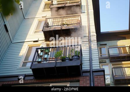 Seattle, WA, USA. 30. April 2022. Rauch kommt aus dem Balkon der Wohneinheit. Das Feuer wurde aufgrund einer noch vorhandenen Brandlast auf dem Ofen ausgelöst. Quelle: Ananya Mishra/Alamy Live News Stockfoto