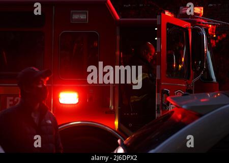 Seattle, WA, USA. 30. April 2022. Ein Feuerwehrmann kommuniziert während eines Wohnungsbrands mit anderen Feuerwehrleuten. Das Feuer wurde aufgrund einer noch vorhandenen Brandlast auf dem Ofen ausgelöst. Quelle: Ananya Mishra/Alamy Live News Stockfoto