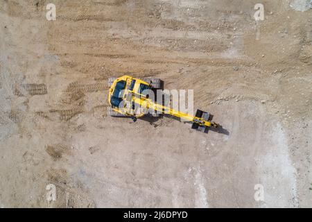 Bagger, der an einem Ort arbeitet, der den Boden gräbt Stockfoto