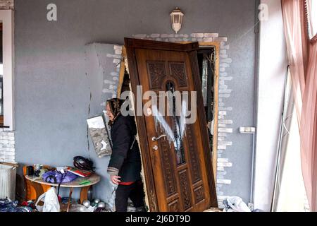 6. April 2022, Borodyanka, Ukraine: Eine Frau kehrt in ihr von der russischen Armee zerstörtes und geplündertes Haus zurück. Borodyanka, eine Stadt in der Region Kiew, etwa 50 km nordwestlich der ukrainischen Hauptstadt, wurde in der ersten Phase des Konflikts von der russischen Armee besetzt. Die kleine Stadt wurde besonders stark von russischen Angriffen getroffen, 90 % der Innenstadt wurden zerstört. (Bild: © Rick Mave/SOPA Images via ZUMA Press Wire) Stockfoto