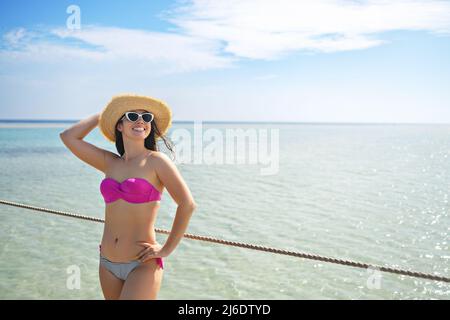 Lächelnde junge Frau mit Strohhut auf Ponton Stockfoto