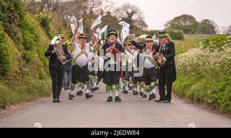 Wilmington, East Sussex, Großbritannien. 1. Mai 2022. Die Longman Morris Men treten bei Sonnenaufgang unter dem Kreidebild des Longman von Wilmington auf, am 1.. Mai, der historisch gesehen der erste Sommertag war. Wilmington, East Sussex, Großbritannien. 1. Mai 2022. Kredit: Reppans/Alamy Live Nachrichten Stockfoto