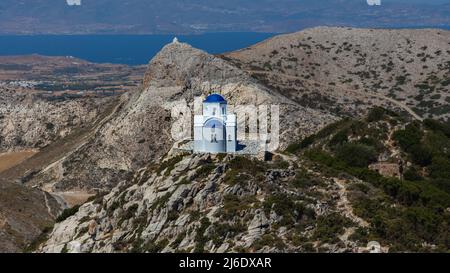 Für die Inseln der kykladen typische christliche Kapelle in den Bergen der Insel Naxos. Weißes Gebäude mit blauem Dach. Der Horizont der Ägäis Stockfoto