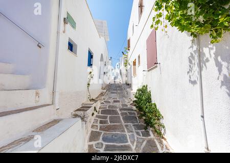 Paros, Griechenland - 3. August 2021: Für die Inseln der Kykladen-Inseln typische enge Gassen mit weißen Häusern und blauen Dächern. Marmorgeflasterter Seitenrand Stockfoto